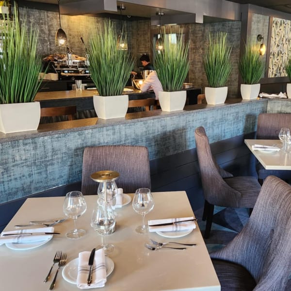 Jessica's Restaurant dining room with set tables, modern chairs, and a bar area with a barista.